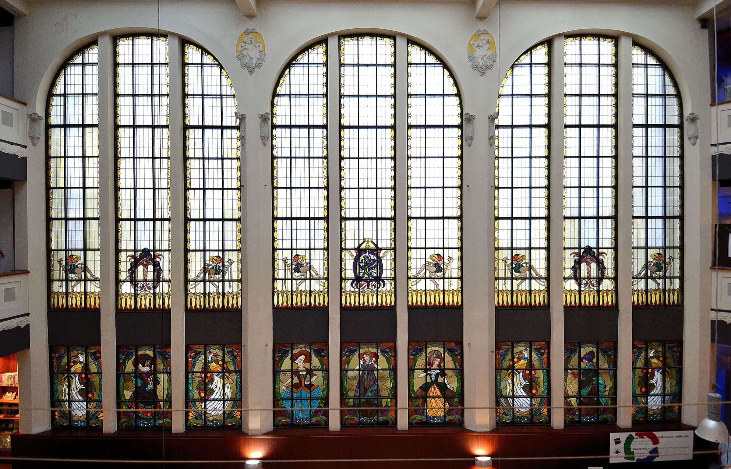 Tall stained-glass windows inside Dom Towarowy Bracia Jabłkowscy