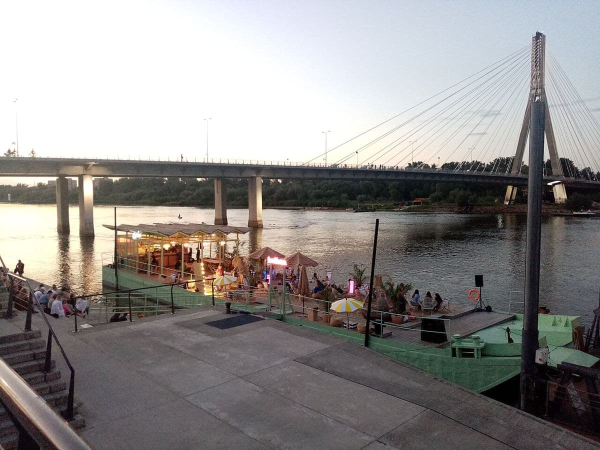 Riverside steps and moored boats on the Vistula boulevards below Świętokrzyski Bridge
